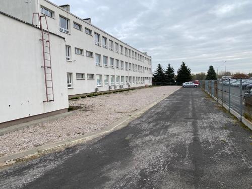 an empty parking lot next to a white building at StarBal in Radom
