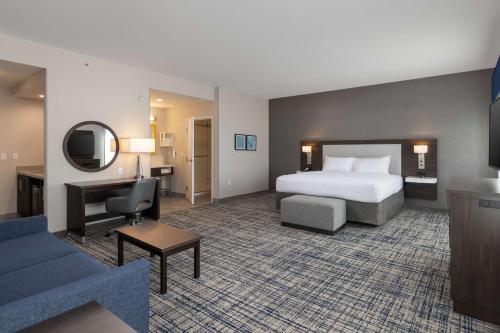 a large hotel room with a bed and a couch at Hampton Inn & Suites Manteca in Manteca