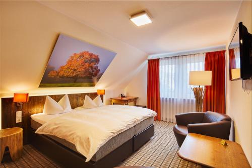 a hotel room with a bed and a chair at Romantikhotel Platte in Attendorn