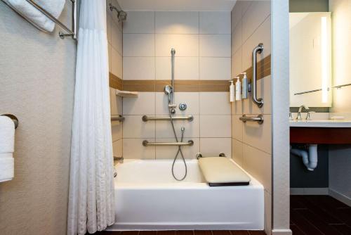 La salle de bains est pourvue d'une baignoire, d'une douche et d'un lavabo. dans l'établissement Hilton Garden Inn Alexandria Old Town National Harbor, à Alexandria