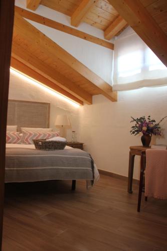 a bedroom with a bed and a table with flowers on it at HOTEL RURAL SANTUI in Horcajuelo de la Sierra