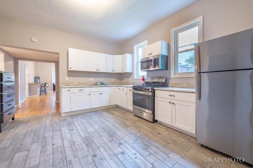 a kitchen with white cabinets and a stainless steel refrigerator at Wonderful Home Close to Downtown Chicago - Free Parking in Chicago