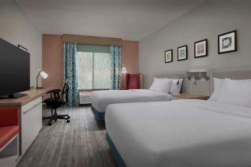pokój hotelowy z 2 łóżkami i telewizorem z płaskim ekranem w obiekcie Hilton Garden Inn Raleigh Capital Blvd I-540 w mieście Raleigh