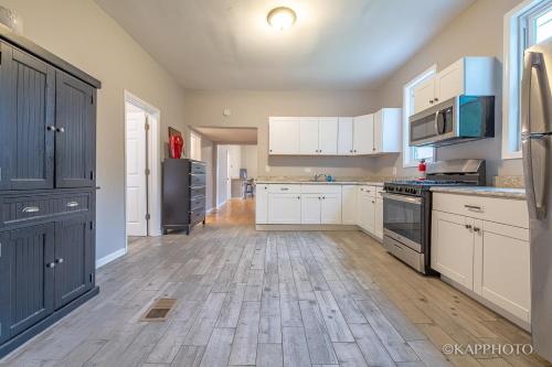 a large kitchen with white cabinets and black appliances at Wonderful Home Close to Downtown Chicago - Free Parking in Chicago