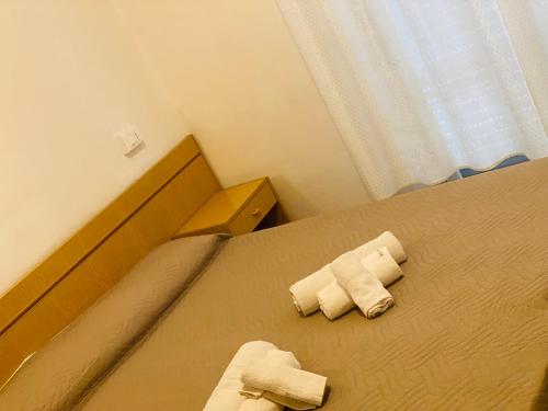 two rolled towels on a bed in a bedroom at hotel iris in Rimini