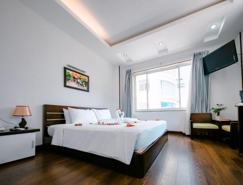 a bedroom with a large white bed and a window at Happy Light Central Nha Trang in Nha Trang