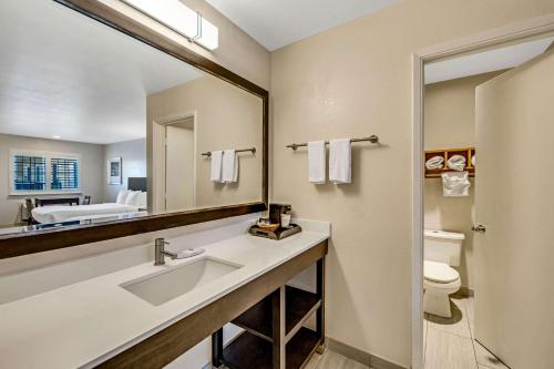 a bathroom with a sink and a mirror and a toilet at Comfort Inn Boardwalk in Santa Cruz