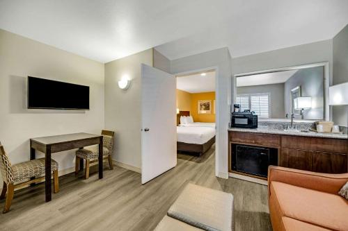 a hotel room with a bedroom with a bed and a desk at Comfort Inn Beach Boardwalk in Santa Cruz