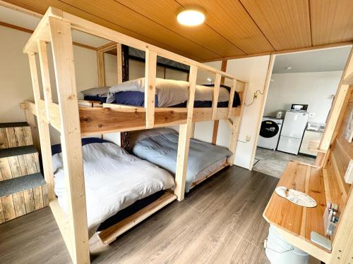 a bunk bed room with three bunk beds at Nobotchi のぼっち 5min walk to Noboribetsu st in Noboribetsu