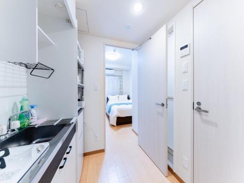 a white kitchen with a sink and a bedroom at Shinjuku/Shin-Okubo Sta 2min walk/Kabukicho 5 min in Tokyo