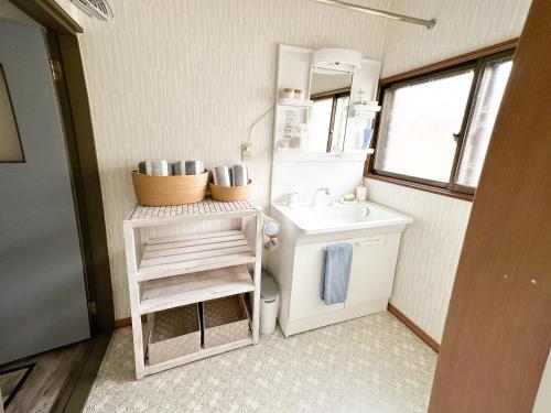 ein kleines Bad mit einem Waschbecken und einem WC in der Unterkunft Nobotchi のぼっち 5min walk to Noboribetsu st in Noboribetsu