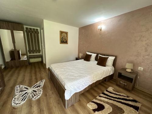 a bedroom with a white bed and a rug at Casa Antonia in Chişcău