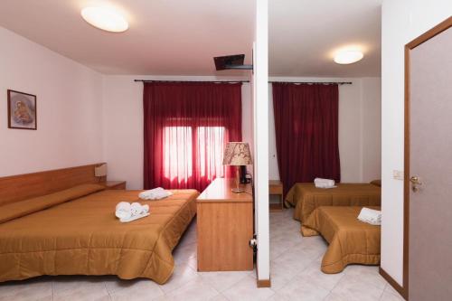 a hotel room with two beds and red curtains at HOTEL BRUNFORTE in Sarnano