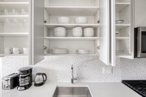a kitchen counter with a sink and white cabinets at South Loop studio w pool gym nr Grant Park CHI-856 in Chicago