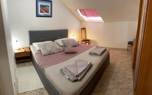 科尔丘拉格吉奇公寓酒店的一间卧室配有一张大床,提供紫色床单和枕头