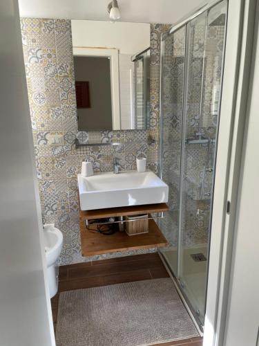 uma casa de banho com um lavatório, um WC e um espelho. em Casa Caracciolo em Lecce