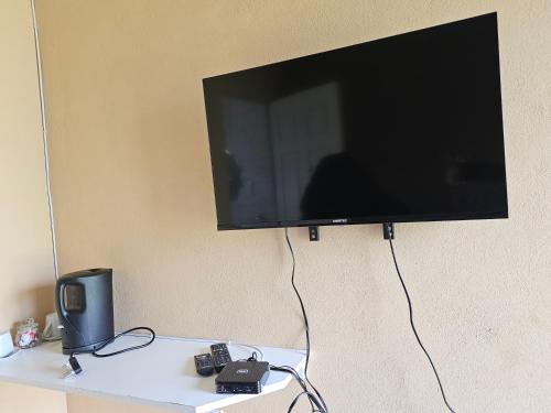 a flat screen tv hanging on a wall at Donsie Guesthouse in Nqutu