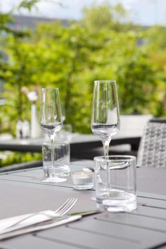 three wine glasses sitting on top of a table at Hilton Garden Inn Munich Messe in Feldkirchen