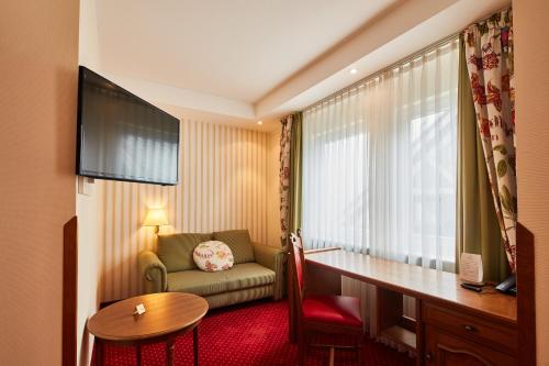 a hotel room with a desk and a chair at Romantikhotel Platte in Attendorn