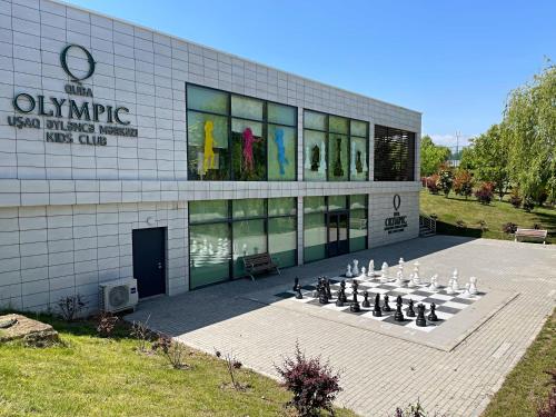 a building with a giant chess set in front of it at Arena Apartments & Villas Guba in Quba