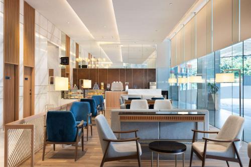 a waiting area with chairs and tables in a lobby at DoubleTree by Hilton Jakarta Bintaro Jaya in Serpong