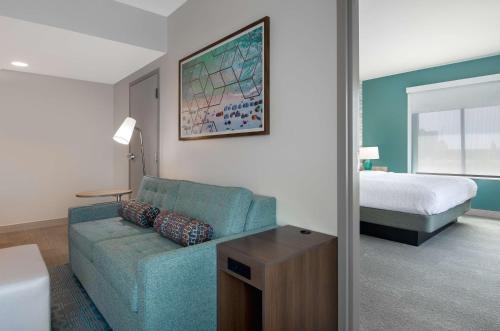a living room with a couch and a bed at Home2 Suites By Hilton Jacksonville Downtown in Jacksonville