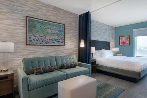 pokój hotelowy z łóżkiem i kanapą w obiekcie Home2 Suites By Hilton Jacksonville Downtown w mieście Jacksonville