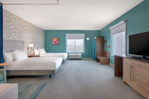 a hotel room with two beds and a flat screen tv at Home2 Suites By Hilton Jacksonville Downtown in Jacksonville