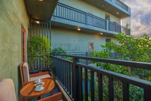 a balcony with a wooden table and a chair with cups on it at Won Residence & Spa in Siem Reap