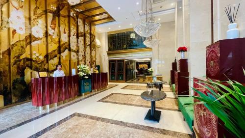 a lobby of a hotel with a man standing at a counter at Golden Silk Boutique Hotel in Hanoi