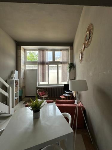 un salon avec une table et une fenêtre dans l'établissement La cabane limougeaude, à Limoges