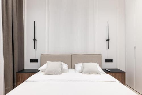 une chambre avec un grand lit avec des draps et des oreillers blancs dans l'établissement La victoire, à Beausoleil