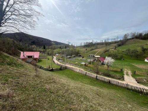 Rai Village في Băniţa: تل به سياج وميدان به بيوت
