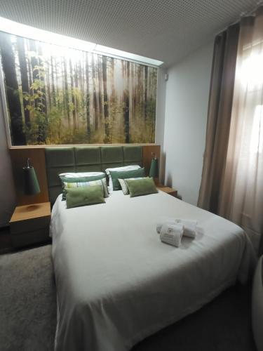a bedroom with a large white bed with green pillows at CASA DE PERAIS in Perais