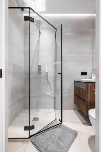 une douche avec une porte vitrée dans une salle de bain dans l'établissement La victoire, à Beausoleil