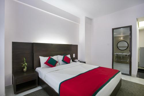 a bedroom with a large bed with a red and white blanket at Nirvana Inn in Sylhet