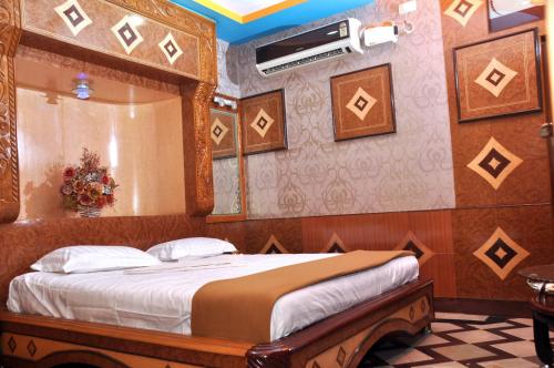 a bedroom with a bed in a room with a mirror at Hotel Shri Swarna's Palace - A Business Class Hotel in Tiruchchirāppalli
