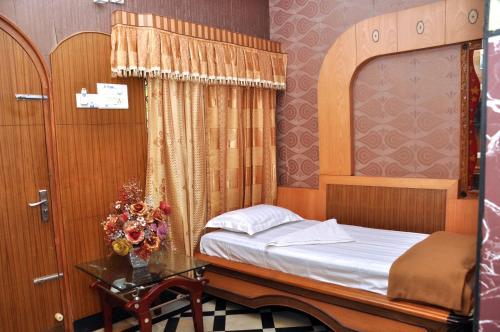 a small bedroom with a bed and a glass table at Hotel Shri Swarna's Palace - A Business Class Hotel in Tiruchchirāppalli