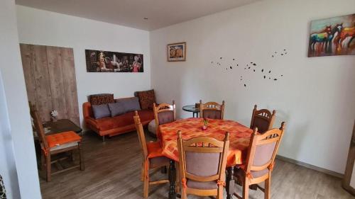 a dining room with a table and chairs and a couch at FeWo Nitteler Zauberpfoten in Nittel