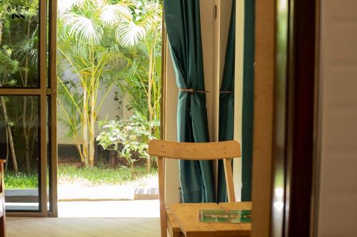 a wooden chair sitting in front of a window at BeezBinn in Hoima