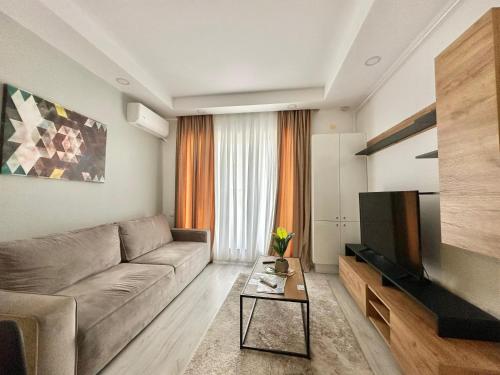 a living room with a couch and a flat screen tv at Double Studio A305 StayInn by Cosmopolis in Ştefăneştii de Jos