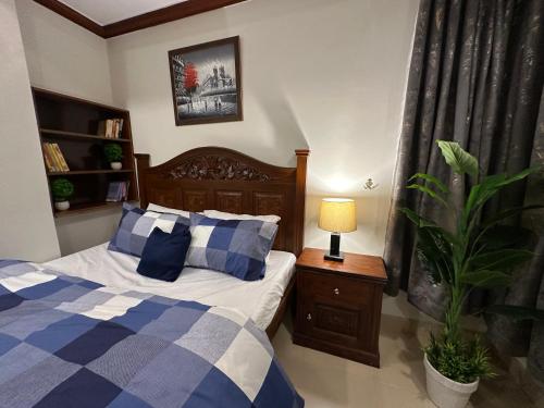 a bedroom with a bed and a lamp and a plant at Shaiz Apartments Bhurban, Murree in Murree