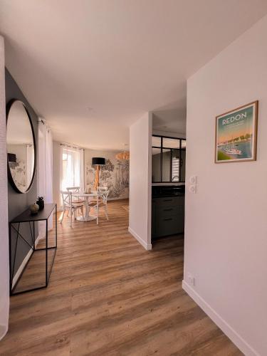 un salon vide avec une table et une cuisine dans l'établissement Au Roupillon du Canal, à Redon