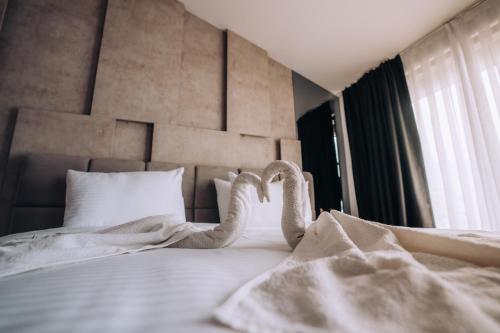 a bedroom with a white bed with a headboard at Hotel Aleksandrija in Ohrid