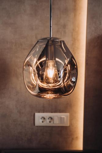 a glass light fixture hanging from a ceiling at Hotel Aleksandrija in Ohrid