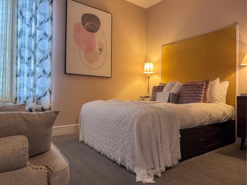 a bedroom with a large bed and a chair at The Chatwal Boutique Hotel in Blackpool