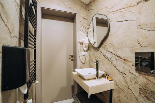 a bathroom with a sink and a mirror at Hotel Aleksandrija in Ohrid