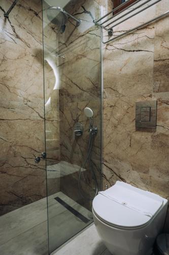 a bathroom with a glass shower with a toilet at Hotel Aleksandrija in Ohrid