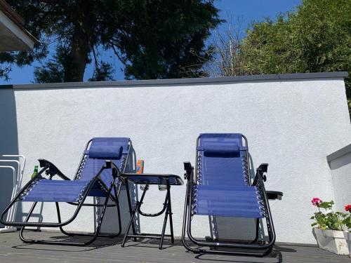 SenonchesにあるChambres Senonches centre-villeの白い壁の横に座る青い椅子2脚