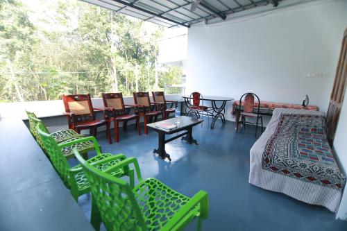 une chambre avec des chaises, une table, une table et des chaises dans l'établissement Natureland Homestay, à Kottayam